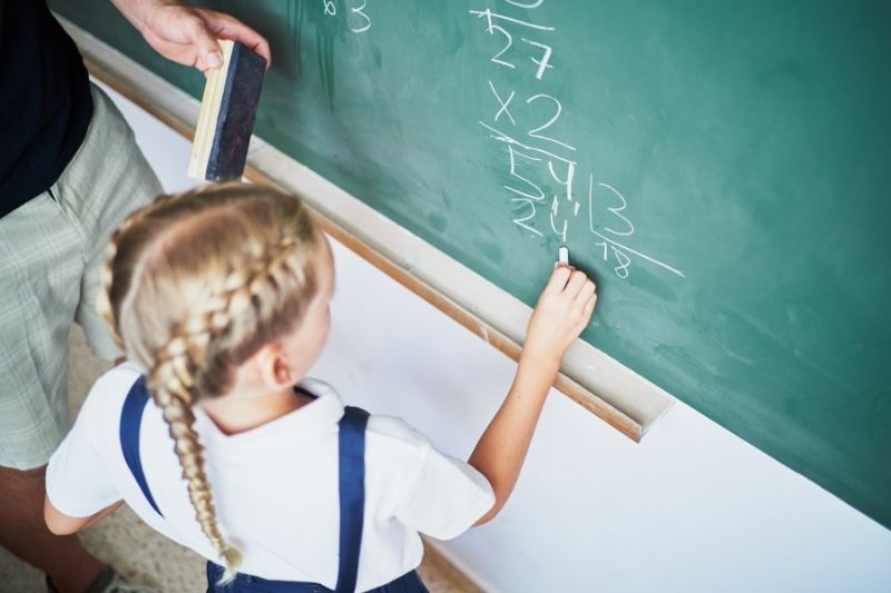 Venezuelan girl in school in Spain writing on a blackboard Girl from Venezuela attending school in Spain